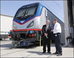 Joseph Boardman, Amtrak President and CEO, left, talks with Michael Cahill, president of Siemens Rail Systems, next to one of the new Amtrak Cities Sprinter Locomotive that was built by Siemens in Sacramento, Calif.  The new electric locomotive will run on the Northeast intercity rail lines and  replace Amtrak locomotives that have been in service for 20 to 30 years.