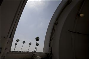 Palm trees are seen through an observatory door at Caltech's Linde + Robinson Laboratory in Pasadena, Calif. A mile above this city, sensors gaze down on the basin from atop Mount Wilson the way a satellite fixates on Earth, collecting pieces of information about Los Angeles' carbon footprint.