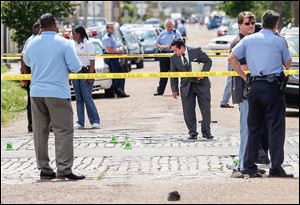 New Orleans police officers investigate at Frenchmen and North Villere streets after gunfire injured 19 at a Mother’s Day parade. Police saw three suspects fleeing the area, but no arrests have been made.