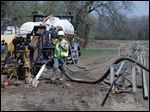  Savoy Energy LP workers install a pipeline in a farm field off  Howell Highway in Adrian. City com­mis­sion­ers signed con­tracts with the firm for oil leases of more than 1,100 acres of city-owned land.