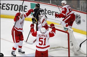 Detroit's Jonathan Ericsson, left, Valtteri Filppula, and Niklas Kronwall celebrate with goaltender Jimmy Howard after defeating Anaheim. The seventh-seeded Wings hope to follow the same path as last year's champions, Los Angeles, which was seeded eighth.
