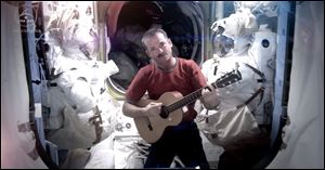 A NASA photo shows astronaut Chris Hadfield recording the first music video from space on Sunday.