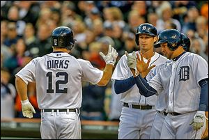 Detroit's Andy Dirks is met at home plate by Don Kelly, center, and Jhonny Peralta, after hitting a grand slam in the fourth inning.