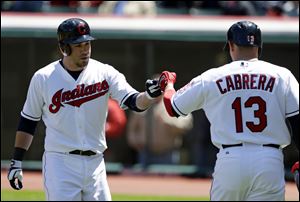 Cleveland Indians' Jason Kipnis, left, is congratulated by Asdrubal Cabrera after Kipnis hit a solo home run off New York Yankees relief pitcher David Phelps in the first inning in the first baseball game of a doubleheader today in Cleveland.