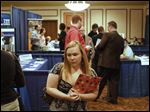  Lindsay Fuerst of Liberty Center, Ohio, makes her way from booth to booth during  the 2013 Career Expo at the Holiday Inn French Quarter in Perrysburg. Organizers say between 300 and 500 potential employees turned out Tuesday to meet representatives from 47 companies. 