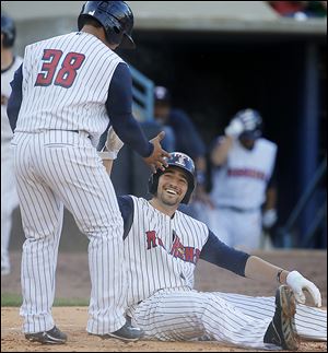 The Hens’ Nick Castellanos, seated, celebrates scoring with Ramon Cabrera in the fourth inning.
