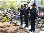  From left, Officer Katrina Welsh-Bills, Chief Derrick Diggs and Officer Berna Guy salute after laying a wreath during the Toledo Area Police Memorial Service at the Toledo Police Memorial Garden, Wednesday.