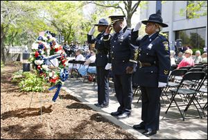 From left, Officer Katrina Welsh-Bills, Chief Derrick Diggs and Officer Berna Guy salute after laying a wreath during the Toledo Area Police Memorial Service at the Toledo Police Memorial Garden, Wednesday.