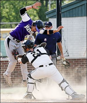 Perrysburg catcher Kyle Durham (21) tags out Fremont Ross' Tyler Wolf at the plate during a Division I sectional baseball game on Thursday in Bowling Green. Perrysburg defeated Fremont 5-3.