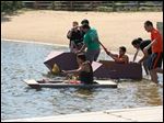  Southview engineering students test the seaworthiness of their cardboard boats on the lake at Olander Park.