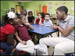  Donovan Vaughn, 15,  interacts with students at the Creative Village Child Devel-opment Center in Toledo as part of the Student African American Brotherhood.