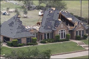 A home in Cleburne, Texas has portions of its roof missing Thursday. Ten tornadoes touched down in several small communities in North Texas overnight, leaving at least six people dead, dozens injured and hundreds homeless.