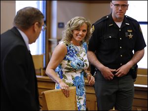 Terri Camp Kruse of Oak Harbor smiles at attorney William Hayes after being granted limited driving privileges by Judge Bruce Winters during a hearing in Ottawa County Common Pleas Court today.