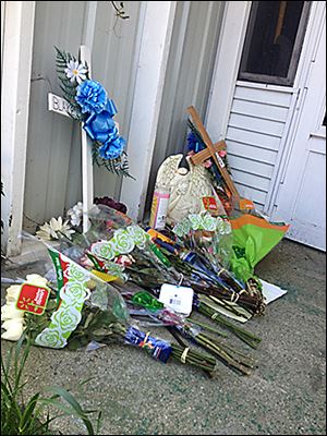 Memorials sit outside the home in Putnam County  where police say two teen boys were killed. Another teen from the home is charged with both murders.