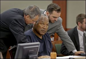 O.J. Simpson, center, talks with defense attorneys Ozzie Fumo, left, and Josh Barry during an evidentiary hearing in Clark County District Court, Thursday in Las Vegas.