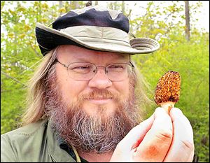 Antoine Delaforterie holds a morel mushroom that he found in Rochester Hills, Mich.