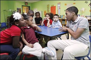 Donovan Vaughn, 15,  interacts with students at the Creative Village Child Devel-opment Center in Toledo as part of the Student African American Brotherhood.