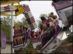  Mackenzie Berry, 12, center, screamed as she and her friend McKenze McDrew, 12, both of Sylvania, rode the Orbiter Friday evening during the 34th Annual Festirama carnival at  St. Joseph Church and School in Sylvania.