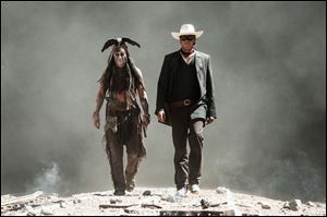 This undated publicity photo released by Disney/Bruckheimer Films shows, from left, Johnny Depp as Tonto and Armie Hammer as The Lone Ranger, in a scene from the movie, 