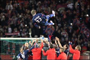 Paris Saint Germain's midfielder David Beckham is thrown in the air by his teammate at the end of their French League One soccer match against Brest, today at the Parc des Princes stadium, in Paris.