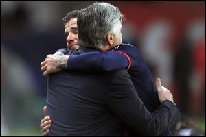 Beckham hugs Paris Saint Germain's coach Carlo Ancelotti, as he leaves the field.
