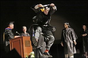 Zander Epps of San Diego jumps as he crosses the stage to receive his bachelor’s degree in interdisciplinary studies during Lourdes University’s commencement ceremony.
