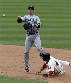 Seattle Mariners' Brendan Ryan throws to first base after forcing out Cleveland Indians' Mike Aviles at second base.