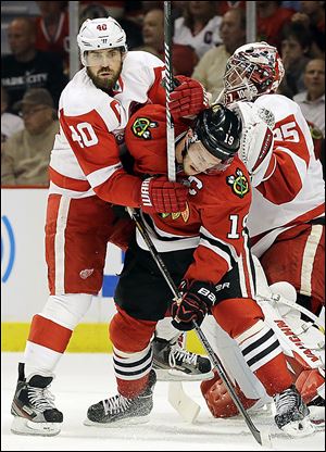 Chicago's Jonathan Toews (19) battles near the goal with Detroit's Henrik Zetterberg. Zetterberg said the Wings played with much more energy than in Game 1.