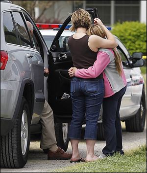 A cousin, left, mourns with the girlfriend of James Safadi, 34, as authorities investigate his shooting death in his home.