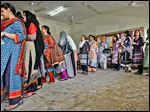  Pakistani women line up to cast ballots during a repolling for the general elections in a Karachi district. The shooting death of a party co-founder kept many home.