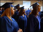  Phylicia Cattladge of South Toledo, center, waits with her fellow graduates backstage before the start of the commencement ceremony for students in the Adult Basic and Literacy Education program today at the Center for Fine and Performing Arts at Owens Community College in Perrysburg Township.