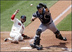 Cleveland Indians' Mike Aviles, left, scores as Seattle Mariners catcher Jesus Montero cannot hold on to the ball in the fourth inning.