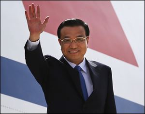 Chinese Premiere Li Keqiang waves as he arrives in New Delhi, India, today.