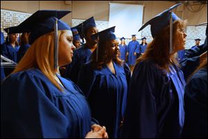 Phylicia Cattladge of South Toledo, center, waits with her fellow graduates backstage before the start of the commencement ceremony for students in the Adult Basic and Literacy Education program today at the Center for Fine and Performing Arts at Owens Community College in Perrysburg Township.
