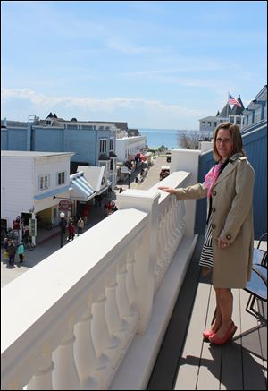 Melanie Libby stands on a balcony at the Bicycle Street Inn. She and Ira Green want to demolish a former fudge shop to build two more hotels on Mackinac Island.