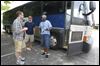  From left: Lifeline volunteer Bryce Roberts, intern Rob Anderson and volunteer Gary Bond converse prior to boarding this bus that will take them from New Harvest Church in Oregon to Monroe, Ohio, where soccer players will kick a soccer ball to Toledo as part of a charity fundraiser.