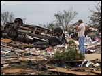  John Warner surveys the damage near a friend's mobile home in the Steelman Estates Mobile Home Park, destroyed in Sunday's tornado, near Shawnee, Okla..