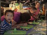  Jorge Aguilar, 6, left, his grandmother Nedra Pike, and parents Ryan Pike and Whitney Mekus react to Sniff Sniff U Stink, an interactive exhibit at Grossology. Each member of the Defiance family took a whiff of something from the human body at the Imagination Station in downtown Toledo on Sunday. 