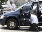  Toledo Police inspect a van with multiple bullet holes after a shooting today on Hoag Street near Belmont Avenue. 