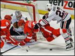  Chicago’s Johnny Oduya checks Detroit’s Justin Abdelkader in front of goaltender Corey Crawford in Monday night’s game.