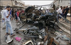 Civilians gather at the scene of a car bomb attack in Kamaliyah neighborhood, a predominantly Shiite area of eastern Baghdad, Iraq, today.