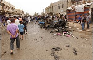 Civilians inspect the scene of a car bomb attack in Kamaliyah neighborhood, a predominantly Shiite area of eastern Baghdad, Iraq, today.