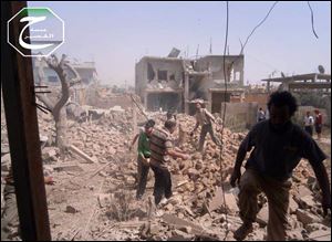 A citizen journalism image provided by Qusair Lens shows Syrians inspecting the rubble of damaged buildings due to government airstrikes, in Qusair, Homs province, Syria.