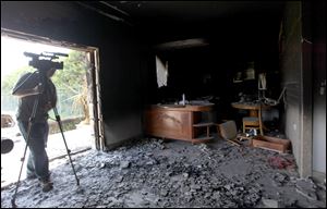 A cameraman films one of  U.S. consulate burnt out offices after an attack that killed four Americans, including Ambassador Chris Stevens on the night of Tuesday, Sept. 11, 2012, in Benghazi, Libya.