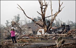 A resident surveys the damage after the tornado hit the area near 149th and Drexel on Monday, May 20, 2013 in Oklahoma City, Okla. 