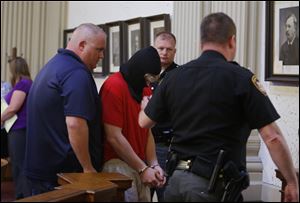 A hooded Michael Aaron Fay leaves Juvenile Court after appearing before Judge Michael A. Borer in connection to aggravated murder at the Putnam County Courthouse in Ottawa.