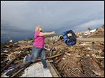  Penny Phillips throws out a bag of salvaged clothing as she goes through the remains of her home on Tuesday in Moore, Okla. that was destroyed by Monday's tornado.