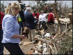  Oklahoma Gov. Mary Fallin, left, picks up a stuffed dog Monday from the rubble of Kimberly Graham's home, at the Steelman Estates Mobile Home Park, which was hard hit in Sunday's tornado, near Shawnee, Okla. Graham is seated at rear in white talking with Red Cross workers.