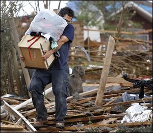 A man carries a drawer and a bag filled with clothes from Rachel Hernandez' home as residents of the Heatherwood Addition in Moore, Okla.,  returned to their homes Tuesday to salvage any items after Monday's destructive tornado.