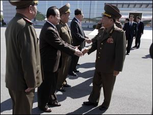 High-ranking North Korean party and military official Choe Ryong Hae, front right, shakes hands with officials as he departs for China as a special envoy of North Korean leader Kim Jong Un, at Pyongyang airport, North Korea today.